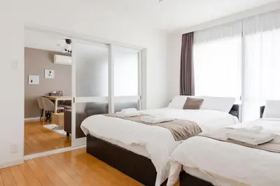 a bedroom with two beds and a mirror at Laputa \u6c60\u888b in Tokyo