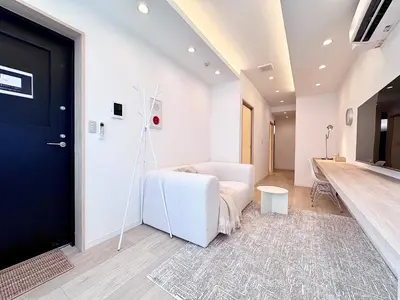 a living room with a white couch and a black door at POINT Apartment Hotel - Ueno - Asakusa - Iriya in Tokyo