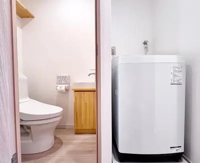 a bathroom with a toilet and a white refrigerator at POINT Apartment Hotel - Ueno - Asakusa - Iriya in Tokyo