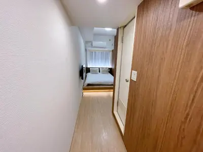 a hallway with a door to a room with a bed at New \u6b4c\u821e\u4f0e\u753a222 \u6771\u65b0\u5bbf\u99c5\u5f92\u6b699\u5206 \u4f0a\u52e2\u4e39\u65b0\u5bbf\u5f92\u6b69 8\u5206 \u65b0\u5bbf\u5fa1\u82d1\u5f92\u6b6914\u5206 in Tokyo