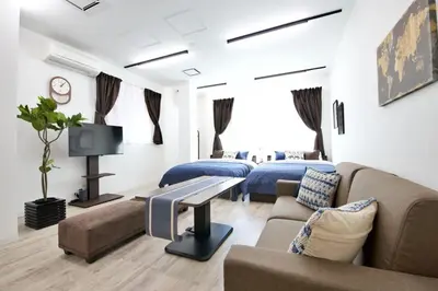 a hotel room with two beds and a couch at Oliver 401 in Tokyo