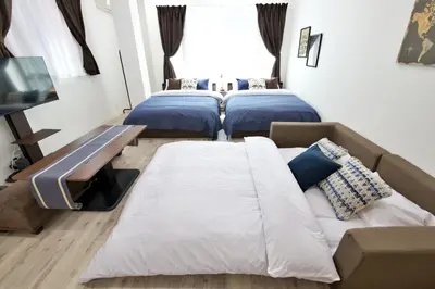 a room with three beds and a couch at Oliver 401 in Tokyo