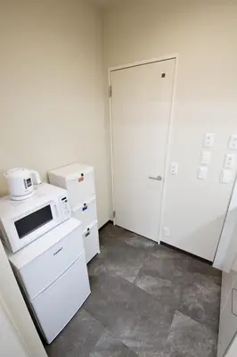 a small kitchen with a microwave and a refrigerator at Oliver 401 in Tokyo