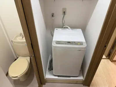 a small bathroom with a toilet and a washer and dryer at Ikebukuro Area 1F01 AbanNishiikeApartment in Tokyo