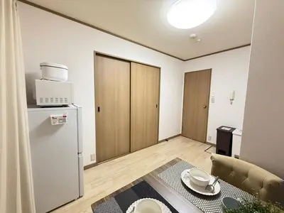 a small living room with a refrigerator and a table at Ikebukuro Area 1F01 AbanNishiikeApartment in Tokyo
