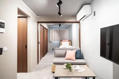 a small room with two beds and a couch at VALUE MAISON kagurazaka in Tokyo