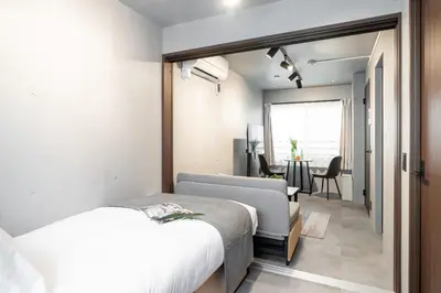 a bedroom with a bed and a chair and a table at VALUE MAISON kagurazaka in Tokyo
