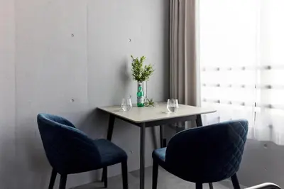 a table with two chairs and a vase with flowers at VALUE MAISON kagurazaka in Tokyo