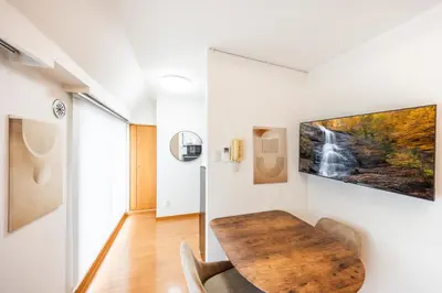 a room with a wooden table and a waterfall painting on the wall at JR Kamata Station is a 3-minute walk, Shinagawa is 7 minutes by train, and Keikyu Kamata Station has direct access to Haneda Airport, Tokyo, Shinagawa, Yokohama, and Ueno in Tokyo