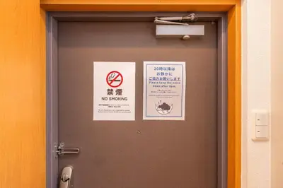 a door with two signs on top of it at JR Kamata Station is a 3-minute walk, Shinagawa is 7 minutes by train, and Keikyu Kamata Station has direct access to Haneda Airport, Tokyo, Shinagawa, Yokohama, and Ueno in Tokyo