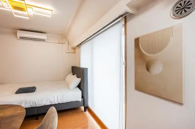a small bedroom with a bed and a sliding glass door at JR Kamata Station is a 3-minute walk, Shinagawa is 7 minutes by train, and Keikyu Kamata Station has direct access to Haneda Airport, Tokyo, Shinagawa, Yokohama, and Ueno in Tokyo