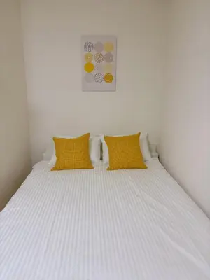 a bedroom with a bed with two yellow pillows at Mori House \u6e0b\u8c37\u672c\u753a in Tokyo