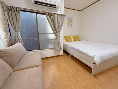 a small room with a bed and a window at Mori House \u6e0b\u8c37\u672c\u753a in Tokyo