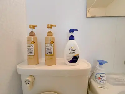 three bottles of cleaning products sitting on top of a toilet at Mori House \u6e0b\u8c37\u672c\u753a in Tokyo