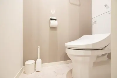 a bathroom with a white toilet and a toilet brush at \u661f\u7a7a\u3068Riviere in Tokyo