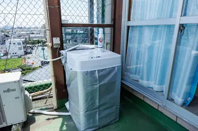 a washing machine sitting on a balcony next to a window at Cruise Inn Kameari in Tokyo