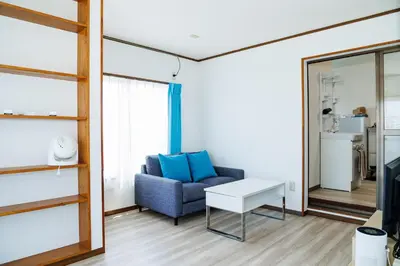 a living room with a blue couch and a table at Cruise Inn Kameari in Tokyo
