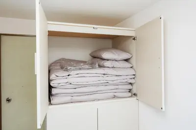 a stack of towels sitting in a closet at Cruise Inn Kameari in Tokyo