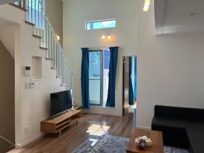 a living room with a tv and a staircase at Direct access to Shinjuku 1 station, atrium living room, super large entrance in Tokyo