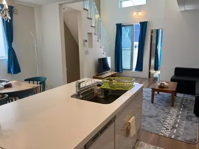 a kitchen with a counter top and a living room at Direct access to Shinjuku 1 station, atrium living room, super large entrance in Tokyo