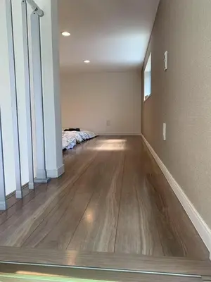 an empty living room with a bed and a hard wood floor at Direct access to Shinjuku 1 station, atrium living room, super large entrance in Tokyo
