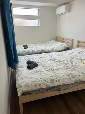 two twin beds in a bedroom with a window at Direct access to Shinjuku 1 station, atrium living room, super large entrance in Tokyo