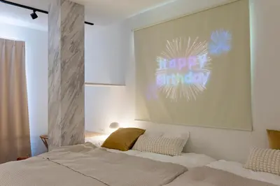 a bedroom with a bed with a happy birthday sign on the wall at Jasmine Style Akasaka in Tokyo