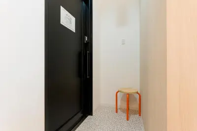 a black door with a stool in a room at Jasmine Style Akasaka in Tokyo