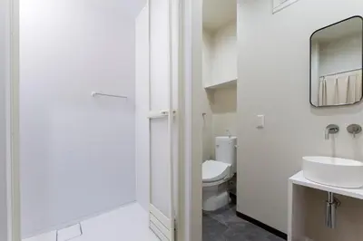 a bathroom with a toilet and a sink and a mirror at Jasmine Style Akasaka in Tokyo