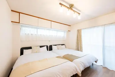 two beds in a bedroom with a window at Vacation Rental -Nagumo301- in Tokyo