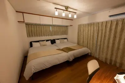 a bedroom with a large bed and a chair at Vacation Rental -Nagumo301- in Tokyo