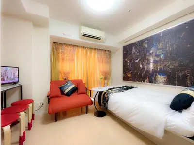 a bedroom with a bed and a red chair at 5mins from JR Kinshicho! Near Asakusa&Skytree! 1101 in Tokyo