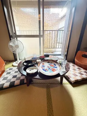 a table with plates on it in a room with a window at Authentic Tatami Quiet Night Ebisu in Tokyo