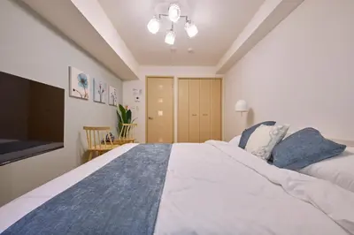 a bedroom with a large bed and a tv at \u30b7\u30e3\u30f3\u30d6\u30eb\u5357\u884c\u5fb3102 in Tokyo