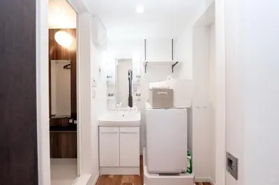 a white bathroom with a sink and a mirror at \u9280\u5ea7\u7dda\u5f92\u6b699\u5206 \u677e\u304c\u8c37\u30a2\u30d1\u30fc\u30c8 in Tokyo