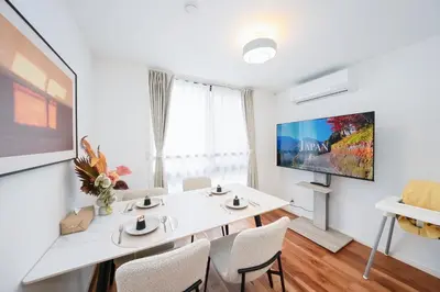 a white dining room with a white table and chairs at \u9280\u5ea7\u7dda\u5f92\u6b699\u5206 \u677e\u304c\u8c37\u30a2\u30d1\u30fc\u30c8 in Tokyo