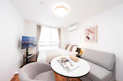 a room with a bed and a couch and a tv at \u9280\u5ea7\u7dda\u5f92\u6b699\u5206 \u677e\u304c\u8c37\u30a2\u30d1\u30fc\u30c8 in Tokyo