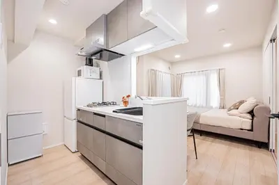 a kitchen with a refrigerator and a stove top oven at ZAITO-Terra hotel \u65b0\u5fa1\u5f92\u753a\u99c5\u5f92\u6b69\u4e09\u5206 in Tokyo