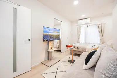 a living room with a couch and a tv at ZAITO-Terra hotel \u65b0\u5fa1\u5f92\u753a\u99c5\u5f92\u6b69\u4e09\u5206 in Tokyo