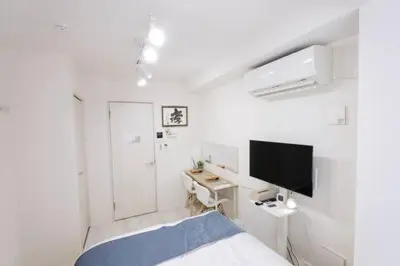 a white room with a bed and a desk and a television at UMI Tokyo Skytree in Tokyo