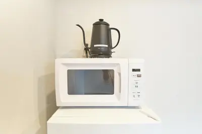 a microwave with a coffee pot on top of it at J-ARC Shinjuku by Tranova in Tokyo