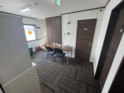 a room with a table and chairs and a door at Sun flower Guest house in Tokyo