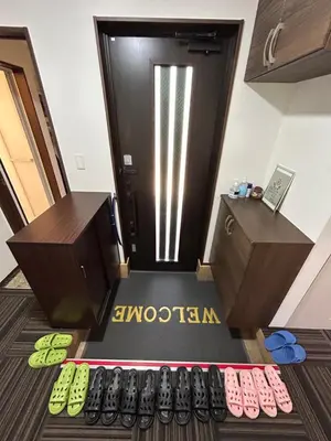 an office with a row of shoes in front of a door at Sun flower Guest house in Tokyo