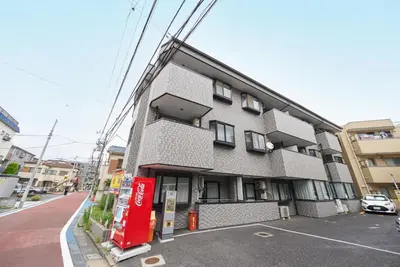 a building with a soda machine in a parking lot at Shamrock Aoto 101 Cozy Tokyo Stay Near Station Airport Disney Access in Tokyo