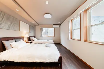 two beds in a room with two windows at New open \u843d\u5408\u5357\u957f\u5d0e\u7ad9 \u6b65\u884c5\u5206 \u8fd1\u65b0\u5bbf \u9644\u514d\u8d39\u505c\u8f66\u4f4d \u4e09\u5c42\u6574\u680b\u51fa\u79df -SJ0394 in Tokyo