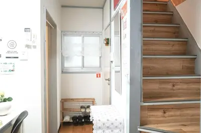 a staircase in a room with a wooden door at \u65b0\u5bbf5\u5206\u96a0\u308c\u5bbf in Tokyo