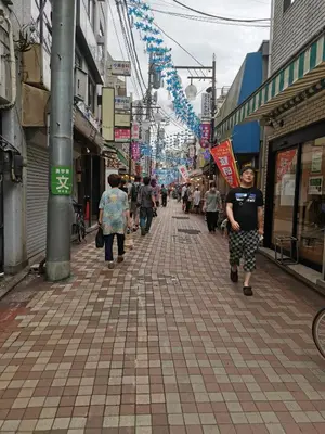 a group of people walking down a street at \u65b0\u5bbf5\u5206\u96a0\u308c\u5bbf in Tokyo