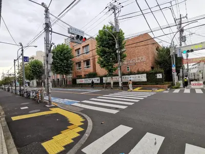 an empty city street with a crosswalk at \u65b0\u5bbf5\u5206\u96a0\u308c\u5bbf in Tokyo