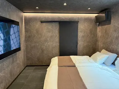 a bedroom with a bed and a tv on the wall at EKVOLI ROPPONGI TOKYO, Private Hotel in Tokyo