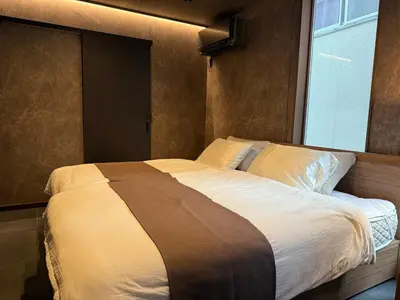 a large bed in a bedroom with a window at EKVOLI ROPPONGI TOKYO, Private Hotel in Tokyo